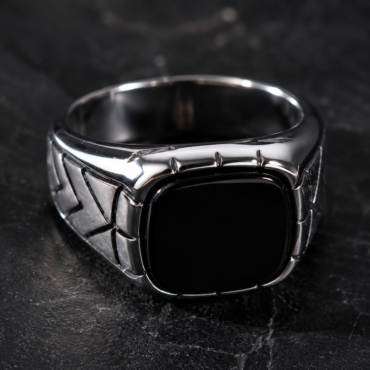 Luxury men's silver signet ring displayed on premium desk